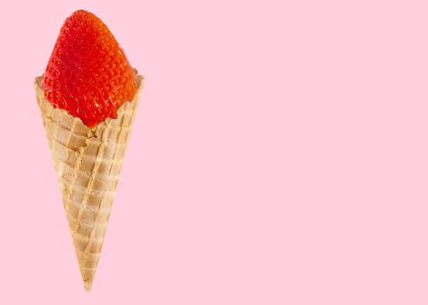 istock Straberrry in waffle cone - healthy dessert concept on pastel pink background 962489800