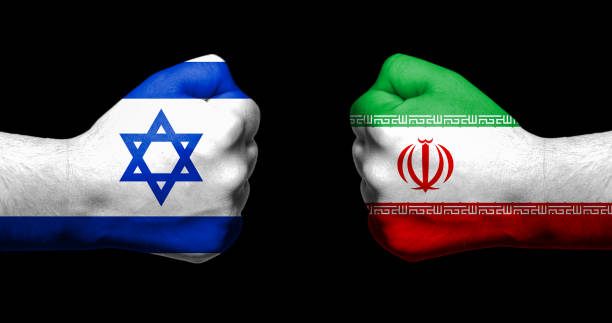 Flags of Israel and Iran painted on two clenched fists facing each other on black background/Israel - Iran conflict concept stock photo