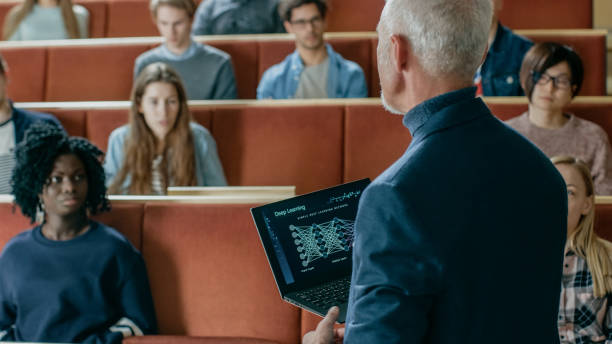 professeur d’informatique lit conférence dans une salle de classe pleine d’élèves multi ethnique. professeur cales portable avec profond learning, infographie intelligence artificielle sur l’écran. - teacher professor science university photos et images de collection