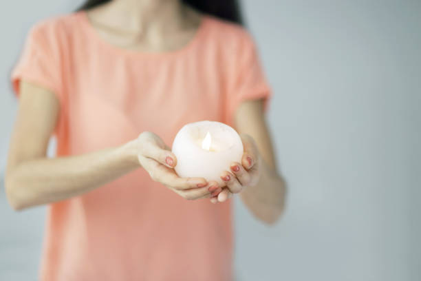 istock close up.a beautiful young woman extends a burning candle 962502106