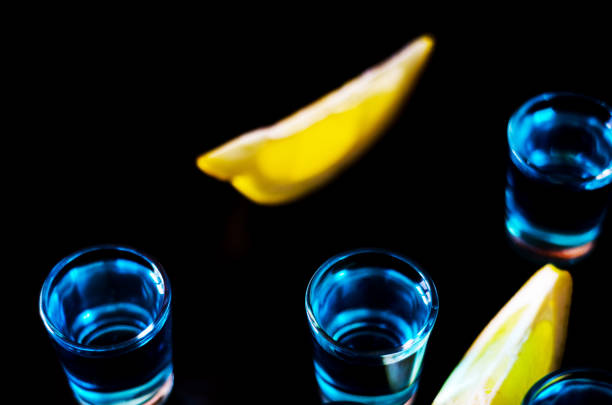 популярный напиток выстрел камикадзе на основе водки, голубой кюрасао и лимонный сок, освежающий напиток - kamikaze cocktail drink lemon стоковые фото и изображения