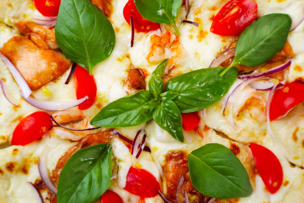 Seafood pizza background with shrimps, basil leaves and melted cheese. Delicious traditional italian food
