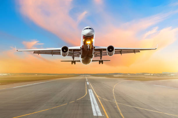 istock Airplane flying arrival landing on a runway in the evening during a bright red sunset. 962512558