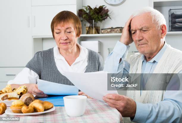 Elderly Couple Consider Contract Stock Photo - Download Image Now - Financial Bill, Senior Adult, 60-64 Years