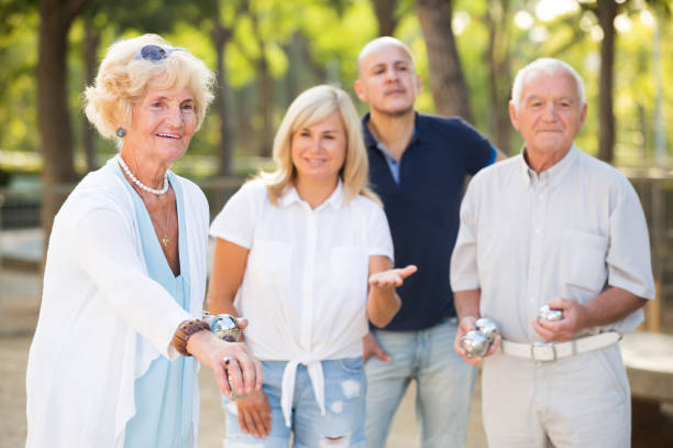 istock Group of positive mature people playing petanque 962518418