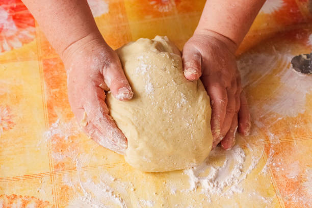 istock Close-Up Of Woman Kneading Dough At Table 962519906