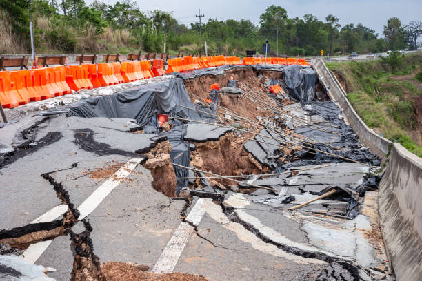 大雨とスライディング地球の丘の中腹の原因上のアスファルト道路の大きな被害 - sink hole ストックフォトと画像