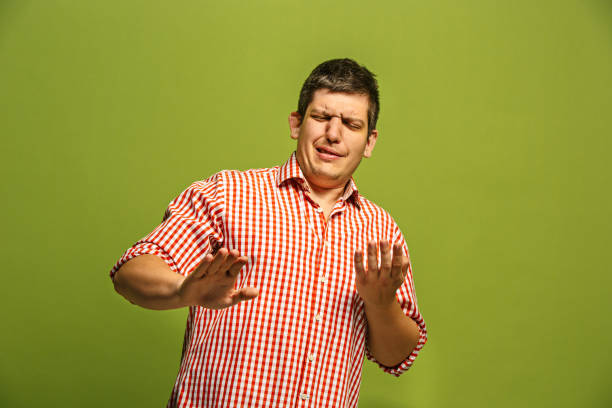 istock Let me think. Doubtful pensive man with thoughtful expression making choice against green background 962524652