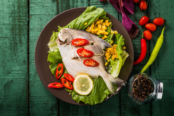 istock fish with vegetables on wooden background 962527308