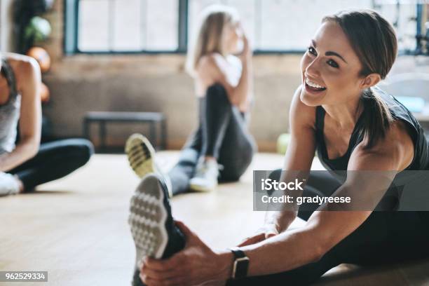 Having A Laugh While Limbering Up Stock Photo - Download Image Now - Exercising, Healthy Lifestyle, Gym
