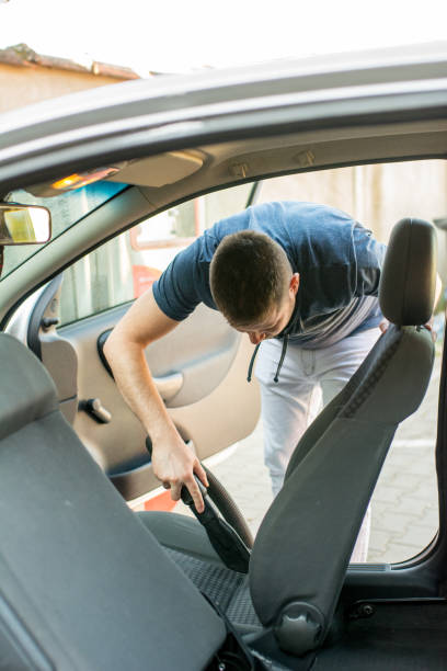 istock Man cleaning interior of his car 962531784