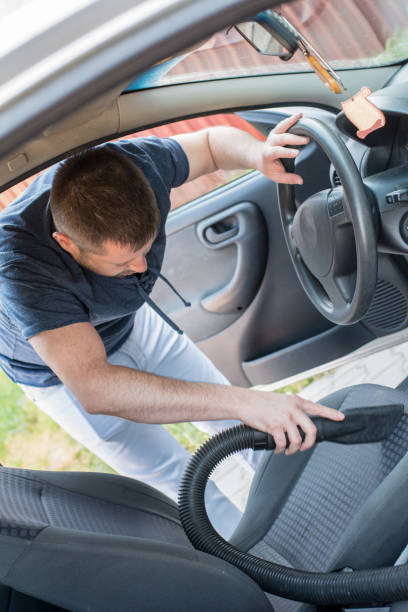 istock Man cleaning interior of his car 962532556