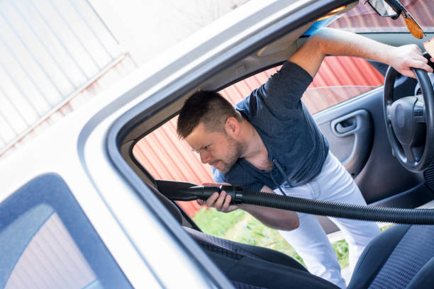 istock Man cleaning interior of his car 962532674