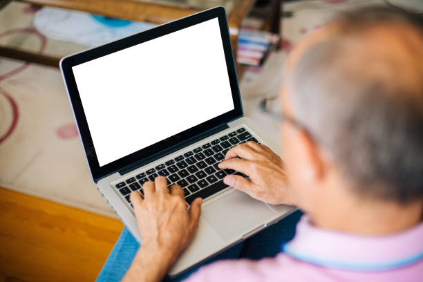 Senior man using blank screen laptop Senior man using blank screen laptop coffee table top stock pictures, royalty-free photos & images