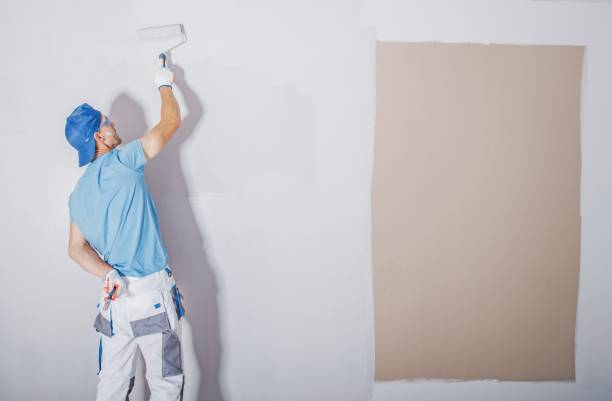 Room Painter at Work Room Painter at Work. Covering Darker Paint by Fresh and Lighter One. Apartment Renovation. Refreshing the Walls. Construction Theme. house painter ladder paint men stock pictures, royalty-free photos & images