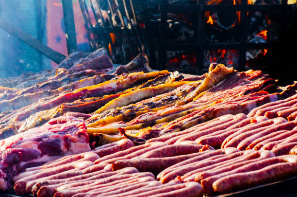 istock different types of meats and sausages stacked on a big grill while cooking 962539160