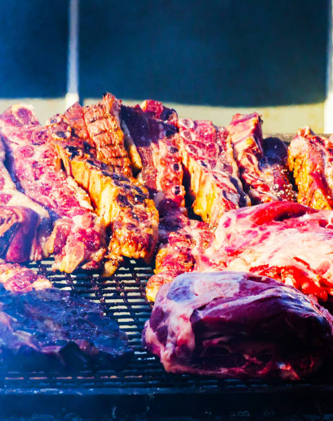 istock different types of meats and sausages stacked on a big grill while cooking 962539222