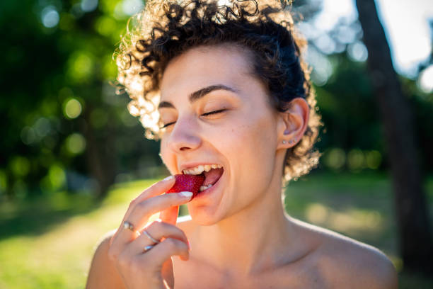istock Cheerful woman eating strawberry 962539408
