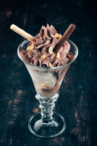 Chocolate ice cream with nuts. On a black wooden background. Copy space.