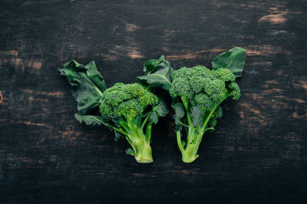 istock Fresh broccoli on a black wooden background. Top view. Copy space.Fresh broccoli on a black wooden background. Top view. Copy space. 962549972