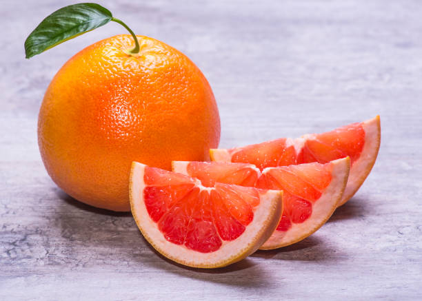 istock Grapefruit whole, and slice, juicy ripe isolated on a gray background 962556794