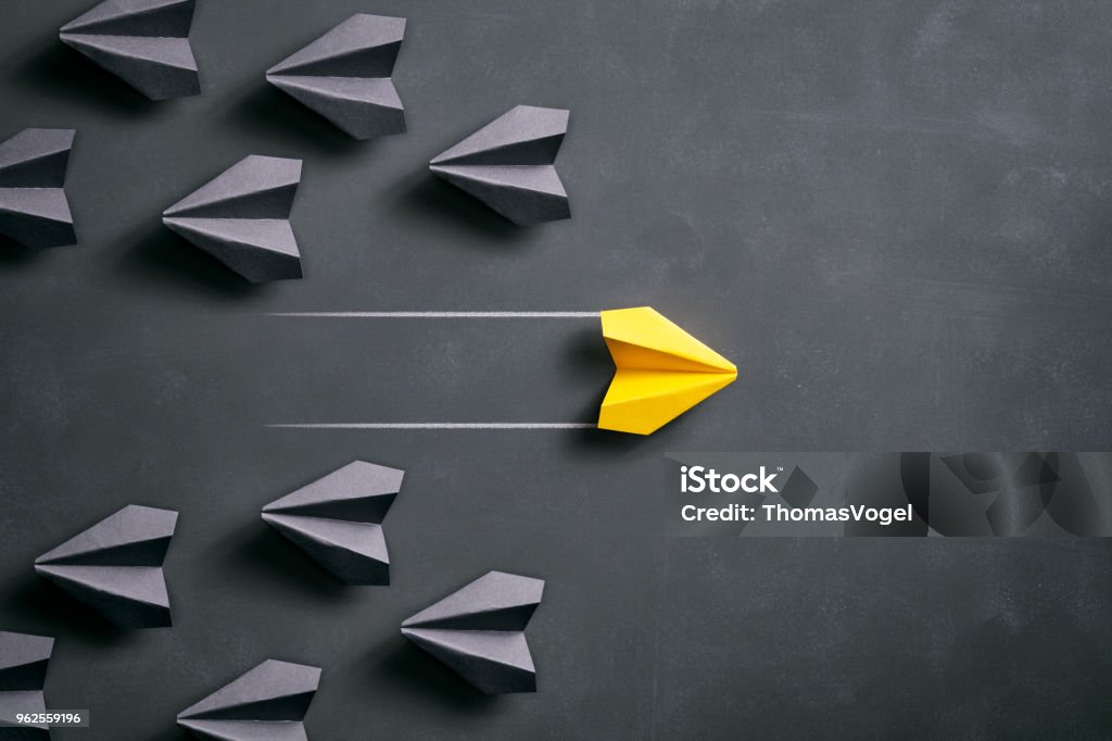 Paper airplane on blackboard - Origami Yellow Concept Conceptual photography with black and yellow paper airplanes on a smudged blackboard. Taking Off - Activity Stock Photo