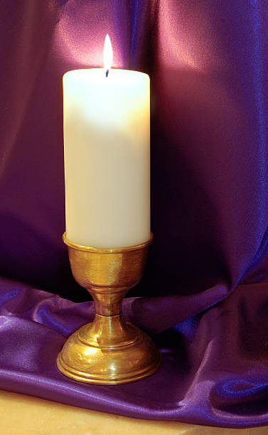 advent candle on purple stock photo