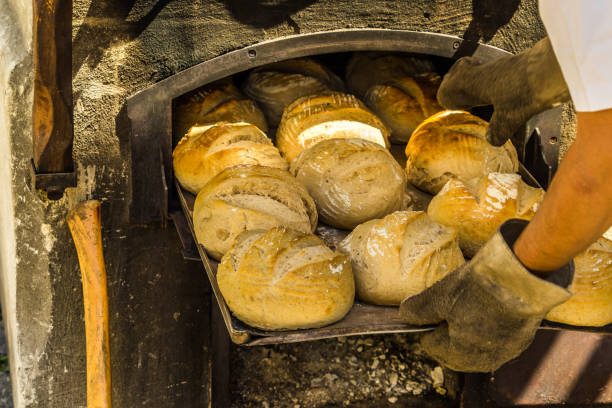 frisch gebackenes brot auf einem backblech im ofen mit brennholz - double oven stock-fotos und bilder