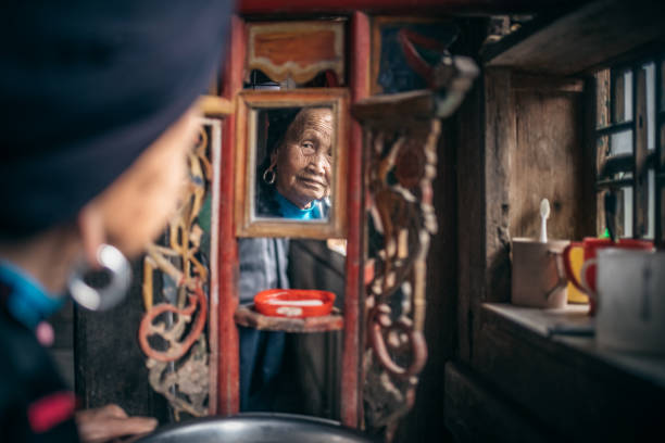 istock old minority chinese woman looking in mirror 962568922