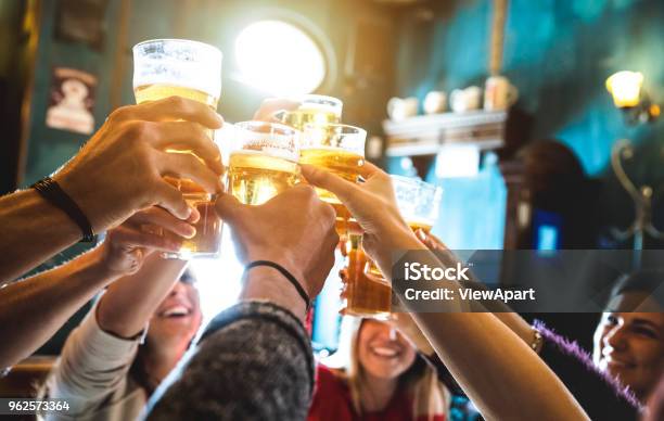 Group Of Happy Friends Drinking And Toasting Beer At Brewery Bar Restaurant Friendship Concept With Young People Having Fun Together At Cool Vintage Pub Focus On Middle Pint Glass High Iso Image Stock Photo - Download Image Now