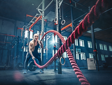 Woman with battle rope battle ropes exercise in the fitness gym.. gym, sport, rope, training, athlete, workout, exercises concept