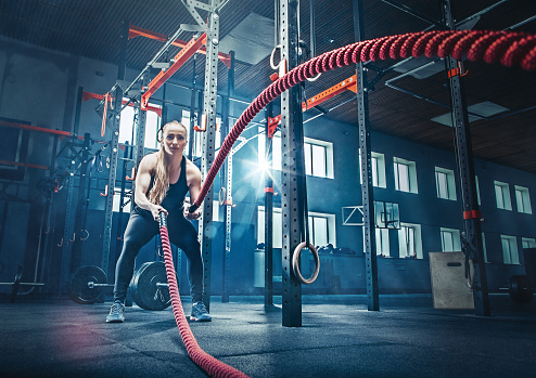 Mujer con batalla Batalla de cuerda cuerdas ejercicio en el gimnasio photo