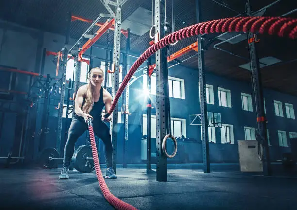 Woman with battle rope battle ropes exercise in the fitness gym.. gym, sport, rope, training, athlete, workout, exercises concept