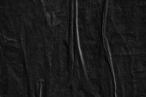 istock Dark black blank paper background creased crumpled surface / Old torn ripped posters scary grunge textures - Stock image 962578890