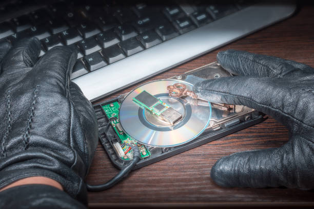 istock Hands of a hacker in leather gloves, hack a computer with a key and media flash drive hard disk 962590448