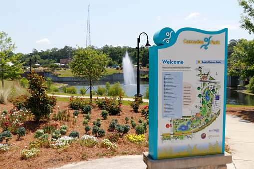 Tallahassee, FL, USA - May 13, 2018: View of Cascades Park beautiful landscape with lake fountain. Sunny day at Cascades Park in Tallahassee with sign and map