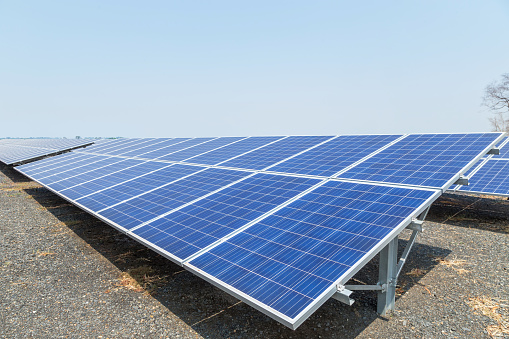 Close up rows array of polycrystalline silicon solar cells or photovoltaics in solar power plant turn up skyward absorb the sunlight from the sun alternative renewable energy on blue sky