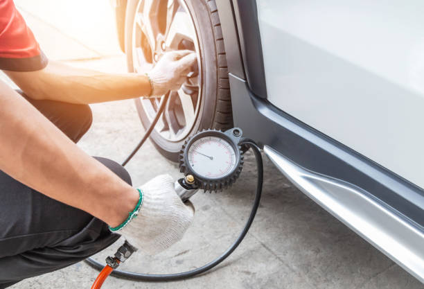 Close up mechanic inflating tire and checking air pressure with gauge pressure Close up mechanic inflating tire and checking air pressure with gauge pressure in service station pressure gauge stock pictures, royalty-free photos & images