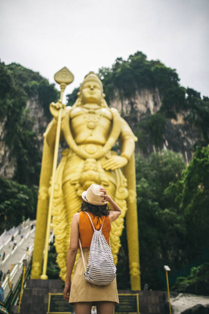 istock Young woman standing in front of the Murugan statue 962600876