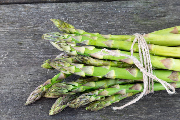 istock Asparagus bunch on a rustic wooden background. 962603734