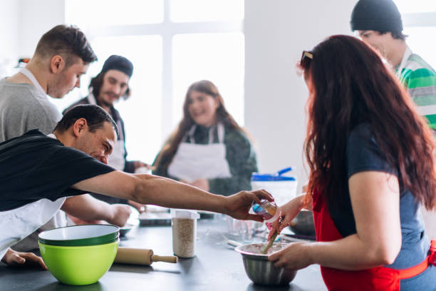 istock Group of people learning to cook in a community center workshop. Cooking class 962604054