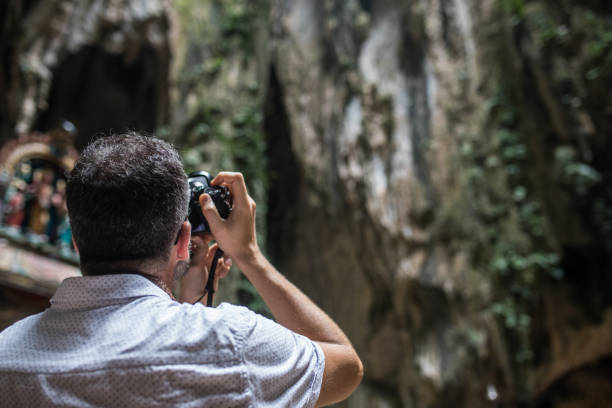 istock Man taking a picture of the Batu caves 962609768