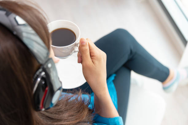 vista superior das mulheres sentado ouvindo música e bebendo café, fazer uma pausa à tarde. - fresh coffee audio - fotografias e filmes do acervo