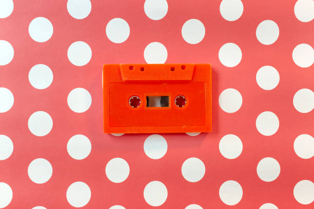 Used orange color cassette tape on orange polka dots background. stock photo