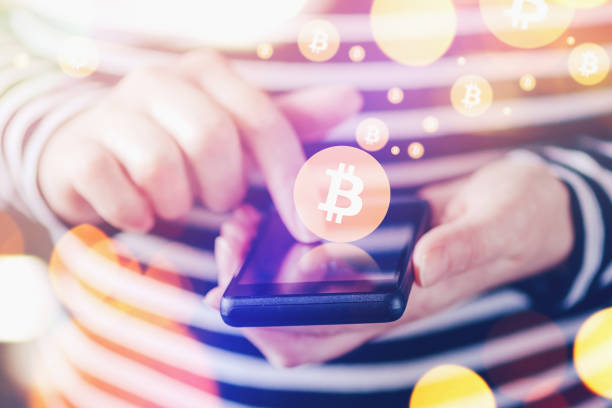 istock Woman paying with Bitcoins over smartphone 962614488
