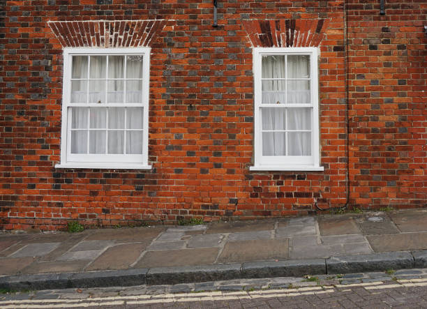 istock Sloped street with two windows on a brick facade. 962614522