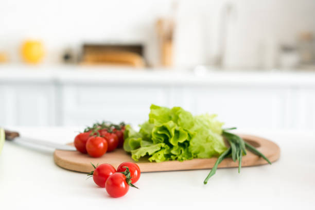 istock cherry tomatoes and salad leaves on cutting board in kitchen 962615634