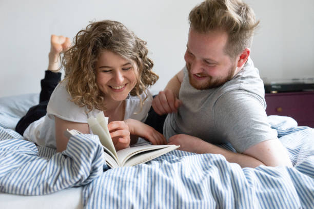 istock Young couple reading book in bed 962619170