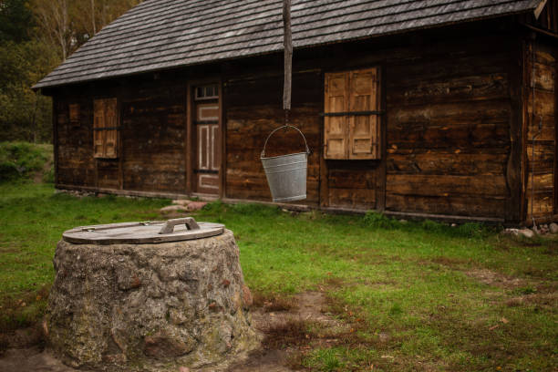 Traditional old wooden house with well in front. in Kampinos Forest, Poland.