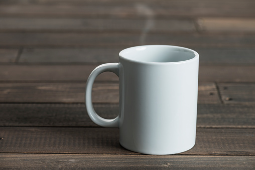 White coffee mug on wooden background.